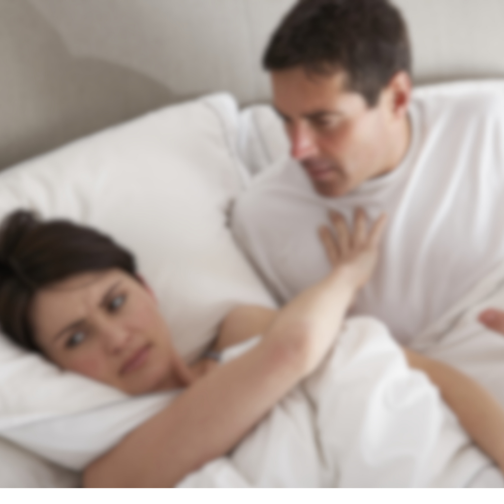 manglende sexlyst i et parforhold illustreret ved en kvinde, der afviser sin partner i sengen, med fokus på følelsesmæssig afstand og udfordringer i intimiteten.