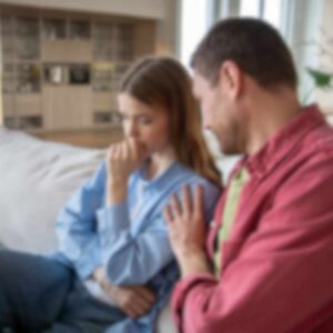En mand forsøger at forklare sig, mens hans partner ser skeptisk og berørt ud – en situation præget af mistillid og mulig benægtelse af utroskab i parforholdet.